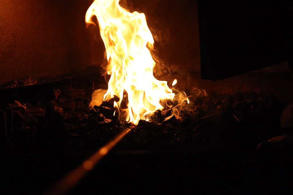 Fuego de carbón encendido en el hogar de una forja